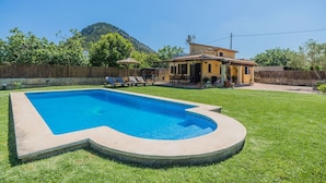 A backyard with a swimming pool, a patio with lounge chairs, and a house with a mountain in the background. - LA RAFAL  ref. VP26 (Pollensa / Pollen��������������������������������������������������������������a)
