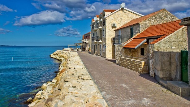 A coastal street lined with stone buildings, a paved walkway, and a rocky shoreline. - Apartment in Bibinje with Terrace, Air condition, WIFI, Washing machine (877-3) (Bibinje)