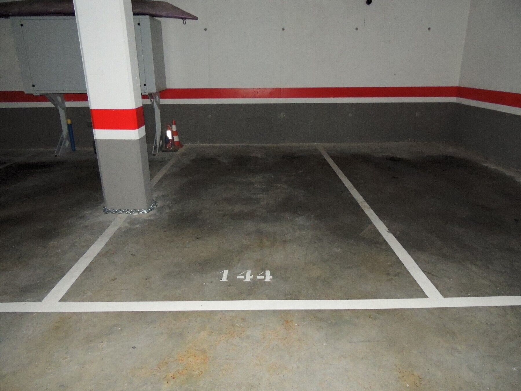 Un estacionamiento con pisos de concreto y líneas blancas.