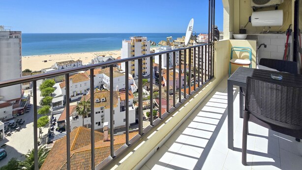 Ein Balkon mit Blick auf den Strand, eine Satellitenschüssel und ein Ventilator.