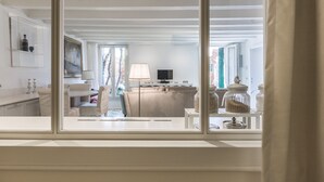 A room with a large window, a sofa, a TV, and a lamp. - Ca' Dell'Ulivo (Venice)