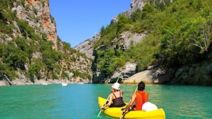 A couple kayaking on a turquoise sea with rocky cliffs and greenery. - Apartment in Omiš with Seaview, Terrace, Air condition, WIFI (3422-2) (Omiš)