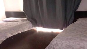 A room with two beds, a dark wooden floor, and a window with curtains. - Beautiful apartment in Essaouira 4158 (Essaouira)