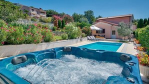 A hot tub with a pool, surrounded by lush greenery and a building with a red roof. - Holiday Home in Ripenda Kras with Loggia, Air condition, WIFI, Washing machine (676-1) (Ripenda Kras)