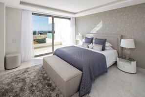 Camera moderna con un letto grande, una panca, un comodino e vista sull'esterno.