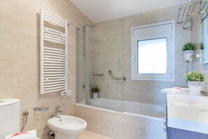A modern bathroom with a glass-enclosed shower, a white sink, and a toilet.