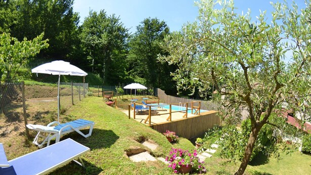 A backyard with a wooden deck, a swimming pool, and lounge chairs. - Vacation Home in Capannori with 1 bedrooms sleeps 2 (Capannori)
