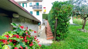 A residential building with a narrow staircase leading to a door, surrounded by lush greenery and a small garden. - Vacation Home in Capannori with 1 bedrooms sleeps 2 (Capannori)