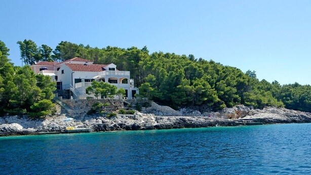 A coastal villa with a white facade, multiple balconies, and a view of the turquoise sea. - Apartment in Tri Porte (Potirna) with Seaview, Terrace, Air condition, WIFI (5208-2) (Vela Luka)