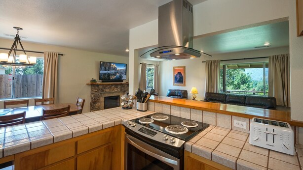 A kitchen with a central island, a stove, a range hood, a built-in oven, and a built-in toaster.