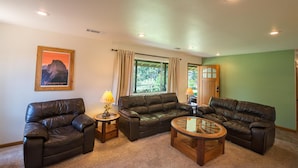 A living room with two leather sofas, a glass coffee table, and a lamp on a side table.