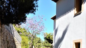 A narrow paved pathway flanked by stone walls and a white building with a window. - Impala - Javea, Costa Blanca (Javea)