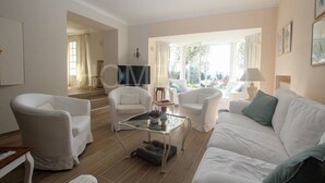 A spacious living room with a large TV, comfortable seating, and a view of the outdoors.
