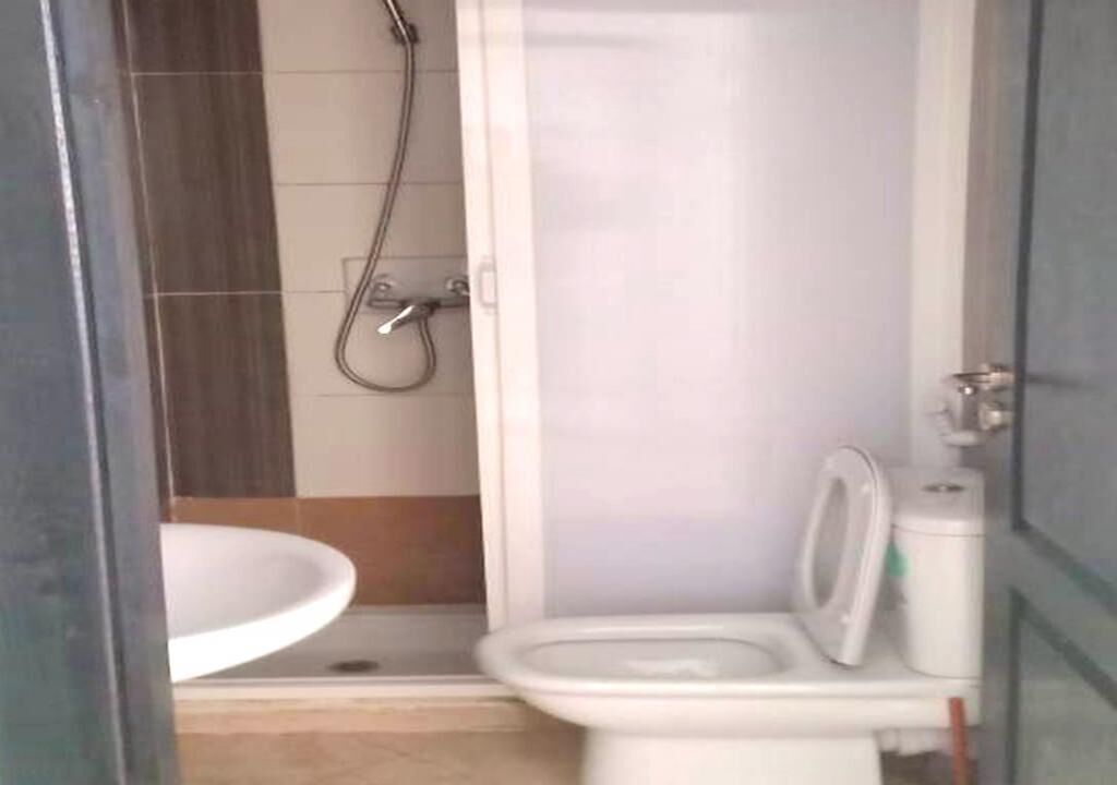 Une petite salle de bain avec des toilettes, un lavabo et une douche.