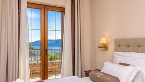 A hotel room with a bed, a nightstand, a lamp, and a view of a lake through a glass door. - Luxury villa RUSTICA with private pool, jacuzzi and outdoor sauna (Linardići)
