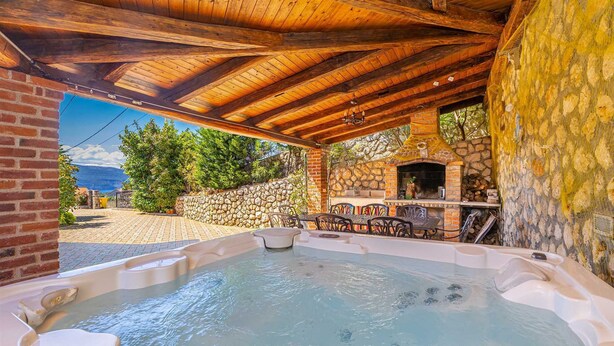 A hot tub area with a stone wall and a brick fireplace. - Luxury villa RUSTICA with private pool, jacuzzi and outdoor sauna (Linardići)