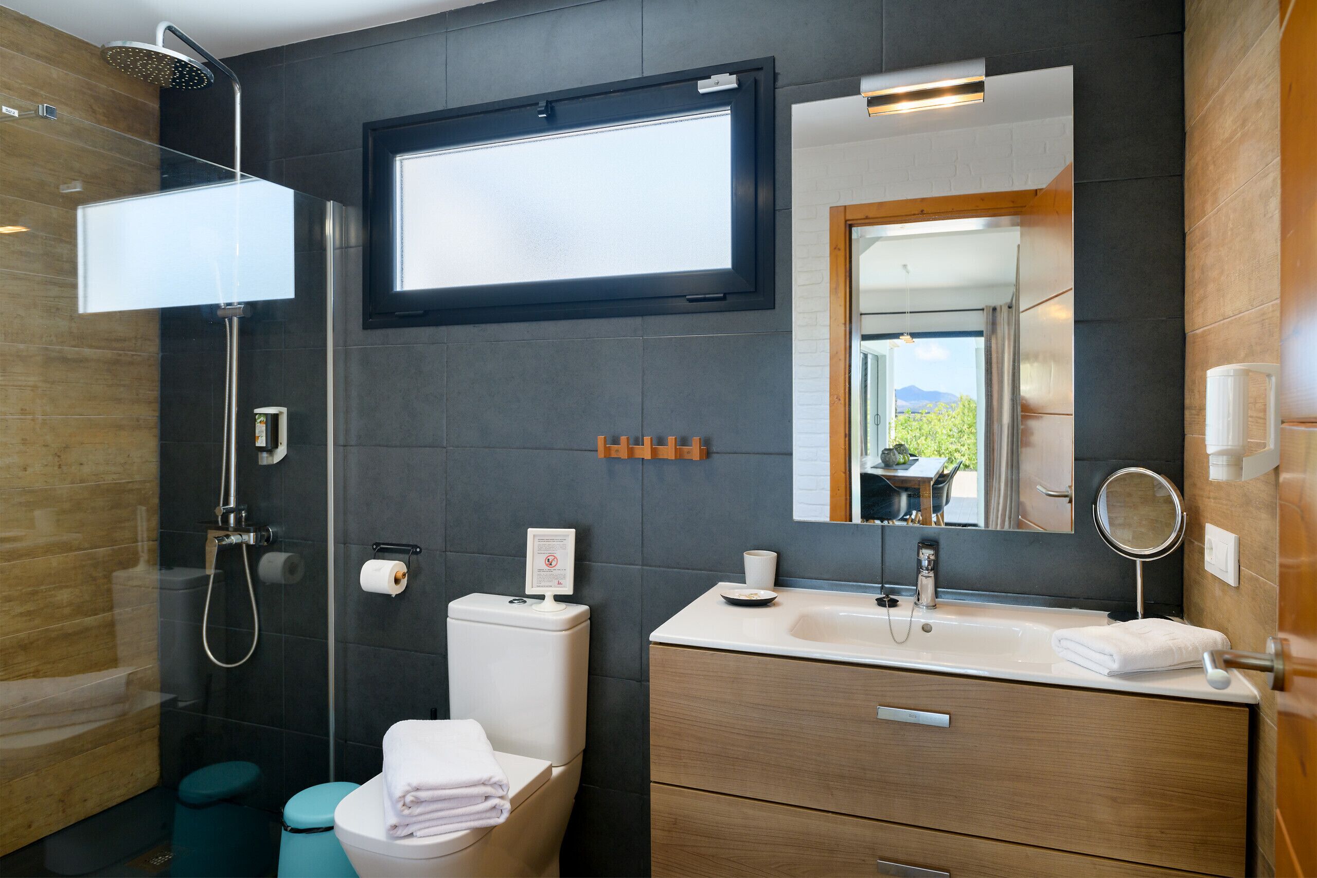 A modern bathroom with a shower, toilet, sink, and vanity.