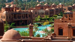A resort with multiple buildings, a central swimming pool, and lush greenery. - Beautiful apartment in River Palm 4397 (Marrakech)