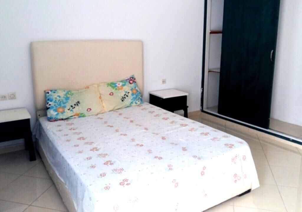 Une chambre à coucher comprenant un lit, une table de chevet, une commode et une armoire.