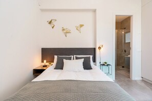 Una camera da letto moderna con un letto grande, un comodino con una lampada e un punto luce a parete.