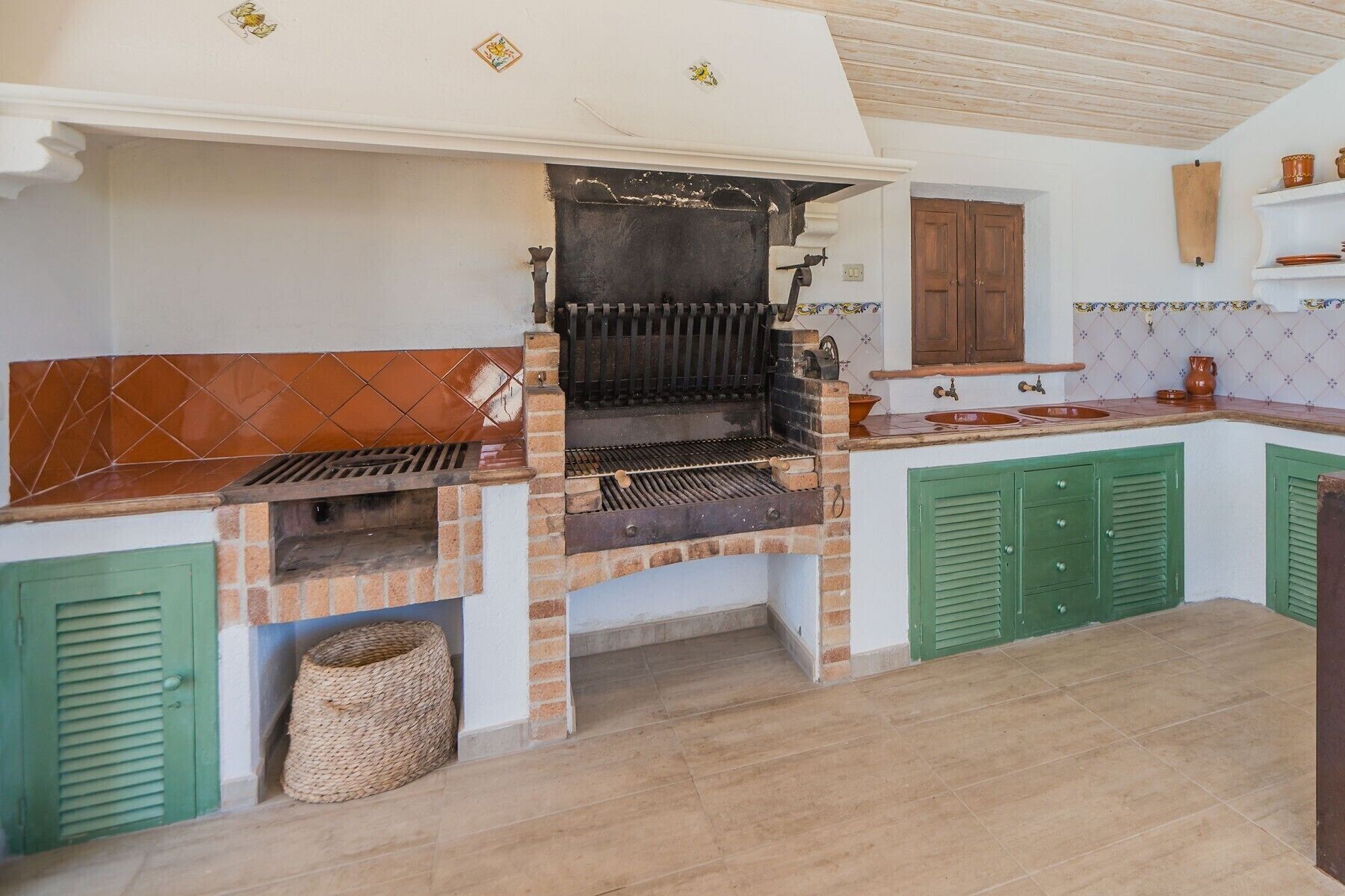 Cuina amb forlla integrada, armaris verds i respatller de rajoles.