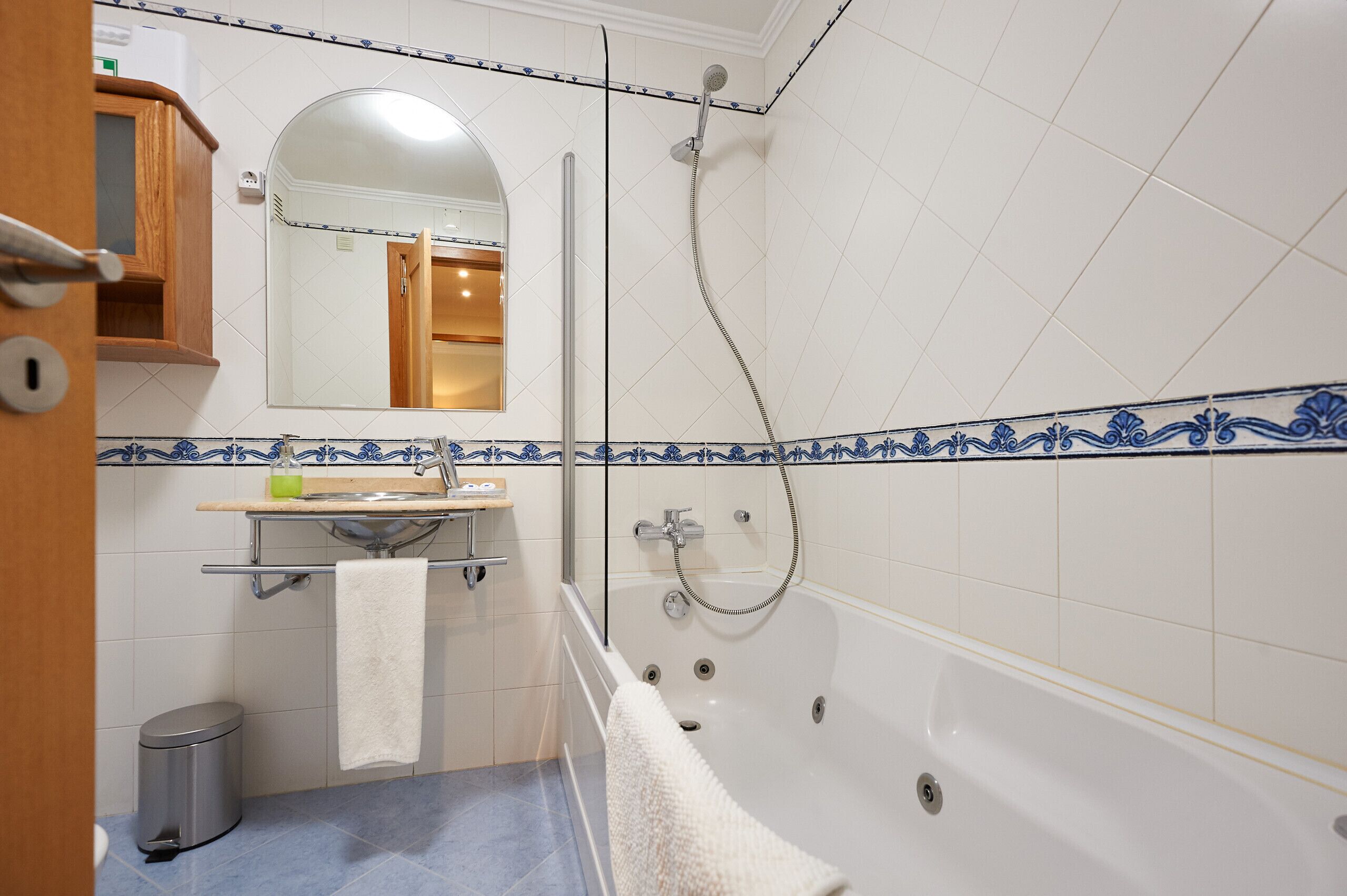 Une salle de bain avec une baignoire, une douche, un lavabo avec un miroir et des toilettes.
