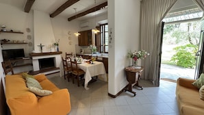 A cozy living room with a sofa and a dining area with a table set for four. - Country House / Farm House in Viareggio with 4 bedrooms sleeps 8 (Viareggio)