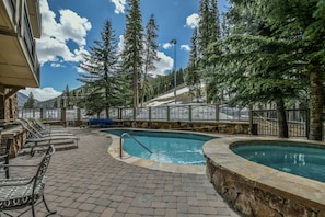 A pool area with lounge chairs and a stone pathway. - Unit With/Private Balcony, Walk to Dining & Shops. (Keystone)
