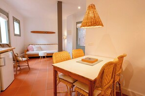 A dining area with a table, chairs, and a hanging light fixture.