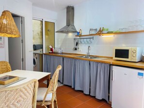 Une cuisine compacte équipée d’un évier, d’un four à micro-ondes et d’un petit réfrigérateur.