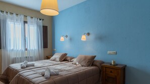 A bedroom with a large bed, two bedside lamps, a nightstand, and a window with sheer curtains. - Casa Rural El Abuelo Luis for 8 people (Molinicos)