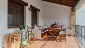 A covered patio with a wooden table, seating area, and potted plants. - Casa Rural El Abuelo Luis for 8 people (Molinicos)
