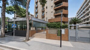 A Burger King restaurant with a pedestrian crossing sign, a staircase leading to the entrance, and a gated entrance with a security box. - Centrally-Located Apartment · AirCon · Shared Pool · UHC CASALMAR 223 (Salou)