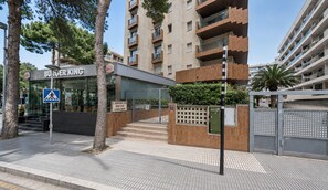A Burger King restaurant with a pedestrian crossing sign, a staircase leading to the entrance, and a gated entrance with a security box.
