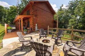 A log cabin with a fire pit and outdoor seating.