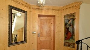 A wooden hallway with a large mirror, a door, and a wall with a decorative painting. - Ferienwohnung "Wilder Kaiser" (Reit im Winkl)