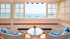 A room with a view of the sea, a round glass table, wicker chairs, and a potted plant. - Casa Elena, 3 Bedroom Playa Blanca Sea View (Playa Blanca)