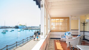 A covered outdoor area with wicker furniture, a view of the harbor, and a tiled floor. - Casa Elena, 3 Bedroom Playa Blanca Sea View (Playa Blanca)
