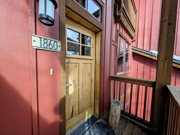 A wooden door with a window, a wooden staircase, and a wooden railing. - Lakeside Escape | Balcony + Lake + Winter Fun (Keystone)