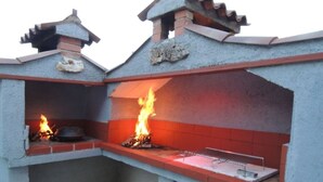 An outdoor kitchen with two barbecue grills, a sink, and a tiled backsplash. - Holiday Home in Poreč with Terrace, Air condition, WIFI, Dishwasher (4400-1) (Porec)