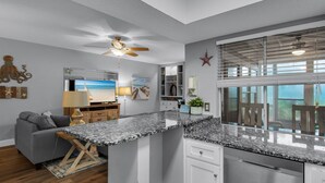 A modern kitchen with granite countertops, white cabinetry, and a built-in dishwasher. - Updated Unit! Pictures coming Soon! (Miramar Beach)