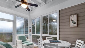 A sunroom with wicker furniture, a ceiling fan, and large windows offering a view of the outdoors. - Updated Unit! Pictures coming Soon! (Miramar Beach)