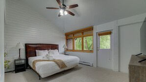A bedroom with a wooden headboard bed, a ceiling fan, a window with a view of trees, and a door. - Captain Molly 3 Bedroom Condo, Centrally Located in PC, Mins to Skiing! (Park City)