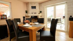 A dining area with a wooden table, black chairs, and a fireplace. - Villa Bianca, Tar | Private Pool Villa in Istria (Rogovici)