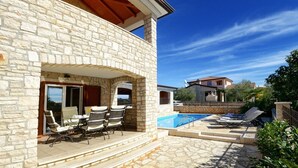 A stone building with a patio, outdoor seating, and a swimming pool. - Villa Bianca, Tar | Private Pool Villa in Istria (Rogovici)
