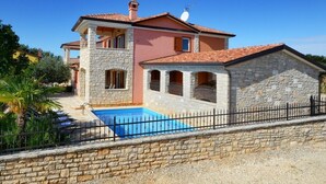 A two-story house with a stone facade, a swimming pool, and a fenced yard. - Villa Bianca, Tar | Private Pool Villa in Istria (Rogovici)