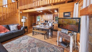 L’intérieur d’une cabane en bois comprend un coin repas, une cuisine et un salon.