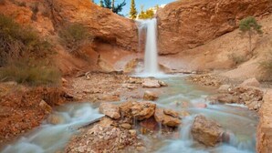 A natural landscape with a waterfall, rocky terrain, and sparse vegetation. - Wranglers Quarters RiverView Cabin - Sevier River Ranch - 1 King bed (Hatch)