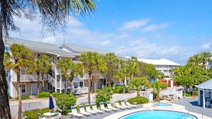 Un resort con piscina, palmeras y una playa.