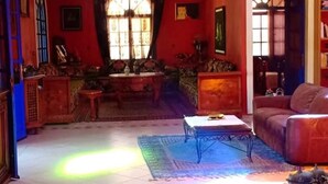 A living room with a sofa, a coffee table, and a patterned rug. - Charming villa with pool 4160 (Essaouira)